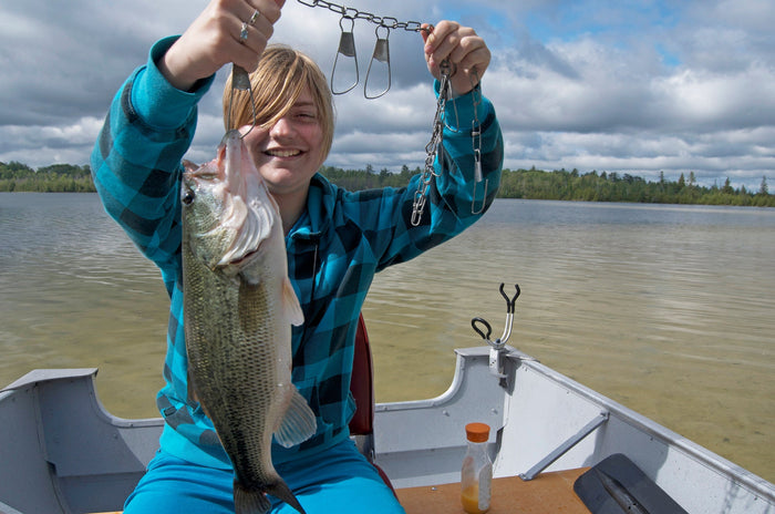Girl with Bass in Back of Boat